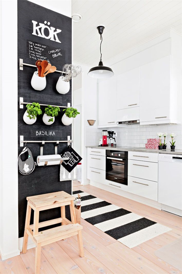 Scandi-simple #white kitchen with #chalkboard feature. Love those simple hanging pots from Ikea rails. From The #Monochrome #Kitchen, the RSD Blog.
